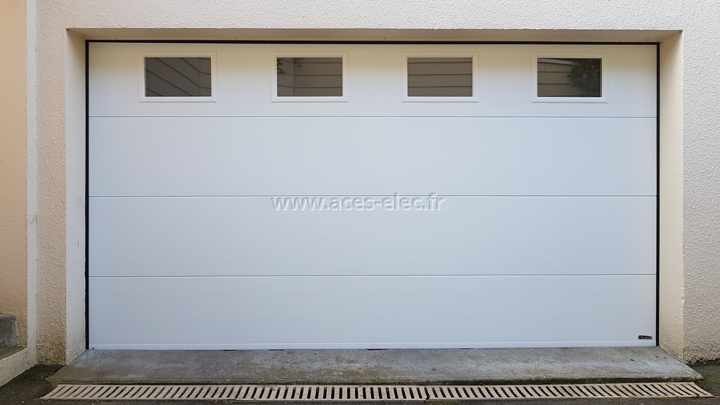 Installation de porte sectionnelle motorisée de qualité avec télécommande ou manuelle de couleur ral blanc sans portillon hauteur 2m.